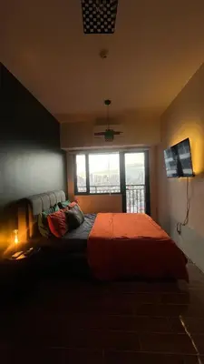 a bedroom with a large bed with a window at Air Residences Minimal Style Unit w Balcony - Near Trident Tower and Salcedo in Manila