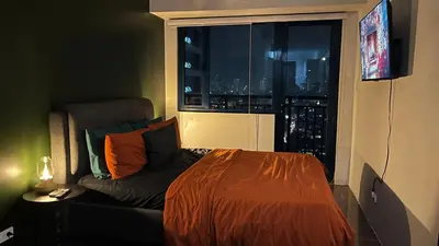 a bed and a couch in a room with a window at Air Residences Minimal Style Unit w Balcony - Near Trident Tower and Salcedo in Manila