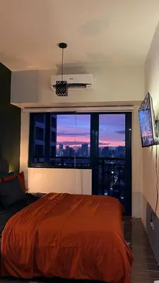 a bedroom with a large bed and a large window at Air Residences Minimal Style Unit w Balcony - Near Trident Tower and Salcedo in Manila