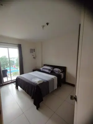 a bedroom with a bed and a large window at Chateau Elysee Condominium in Manila