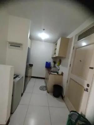 a small kitchen with a white floor and a door at Chateau Elysee Condominium in Manila