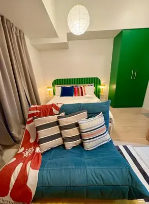 a bedroom with a bed with pillows on it at BGC Uptown Parksuites 1BR 14P in Manila