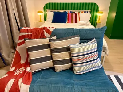 a bed with pillows on top of it next to a bed with a bed at BGC Uptown Parksuites 1BR 14P in Manila