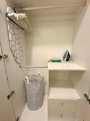 a walk in closet with a white shelf and a basket at BGC Uptown Parksuites 1BR 14P in Manila
