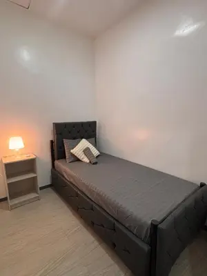 a small bedroom with a bed and a night stand at Pasay Transient Rooms in Manila