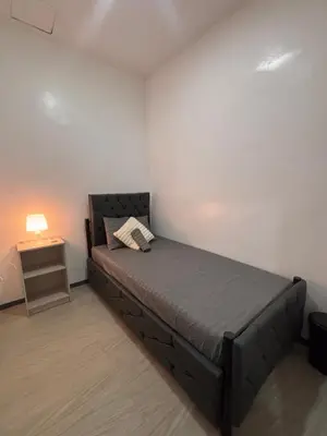 a bedroom with a bed and a side table at Pasay Transient Rooms in Manila