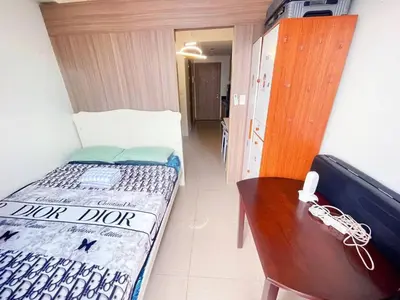 a small room with a bed and a wooden table at SHORE 2 TOWER 3 Near MOA Easy Vacation Shopping Center in Manila