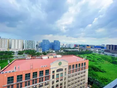 a building with a red roof in a city at SHORE 2 TOWER 3 Near MOA Easy Vacation Shopping Center in Manila