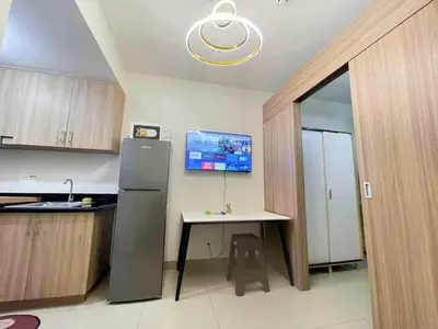 a kitchen with a refrigerator and a table and a tv at SHORE 2 TOWER 3 Near MOA Easy Vacation Shopping Center in Manila