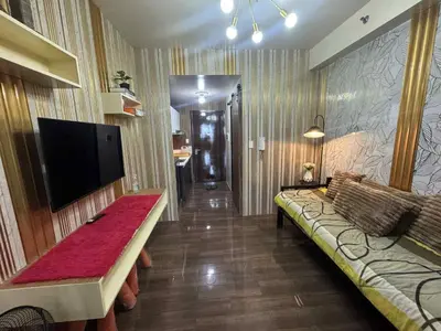 a living room with a couch and a flat screen tv at Air Residences 2111k'Pads in Manila