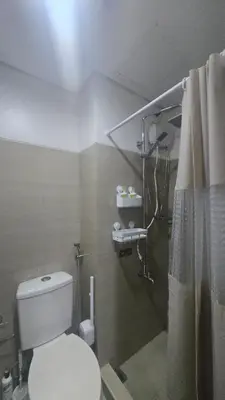 a bathroom with a white toilet and a shower at Book ME at Shore Residences Tower D near Airport & Mall of Asia in Manila