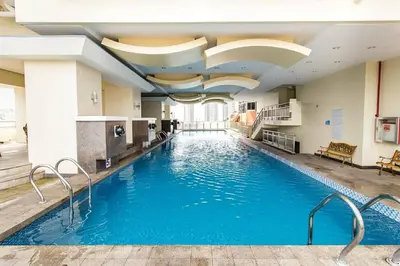 a large pool in a hotel with blue water at Birch Tower Manila by JL in Manila