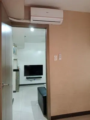 a door leading into a room with a television and a room with a unintention at Affordable condotel paranaque in Manila