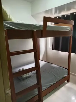 a bunk bed in a dorm room with a ladder at Affordable condotel paranaque in Manila