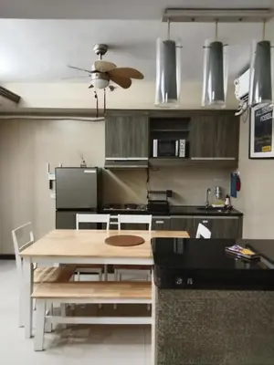 a kitchen with a wooden table in a kitchen at Affordable condotel paranaque in Manila