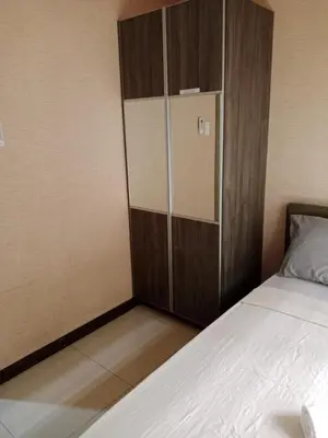 a bedroom with a cupboard next to a bed at Affordable condotel paranaque in Manila
