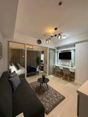 a living room with a couch and a bedroom at Transient Home Serenity in Manila