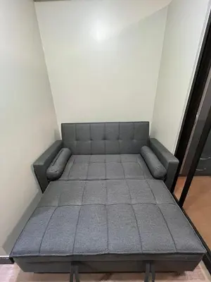 a bed in the corner of a room at Calathea Place - Bel's Cozy Staycation in Manila