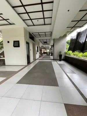 an empty hallway of a building with white and brown floors at Calathea Place - Bel's Cozy Staycation in Manila