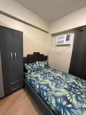 a bedroom with a bed with a blue and green bedspread at Calathea Place - Bel's Cozy Staycation in Manila