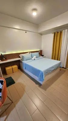 a bedroom with a large bed with blue sheets at 10P North Wing in Manila