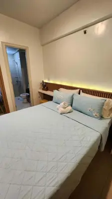a bedroom with a large white bed with blue pillows at 10P North Wing in Manila