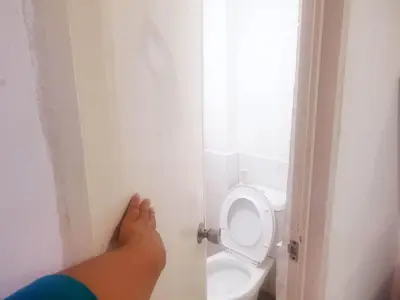 a person standing in a bathroom with a toilet at Fernica Boarding House in Carmona
