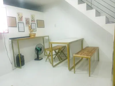 a room with two tables and a bench and stairs at Fernica Boarding House in Carmona
