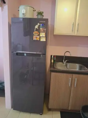a black refrigerator in a kitchen with a sink at 4V North Wing in Manila
