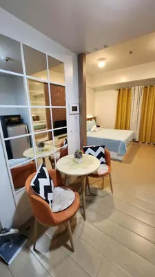 a hotel room with a bed and a table and chairs at 4V North Wing in Manila