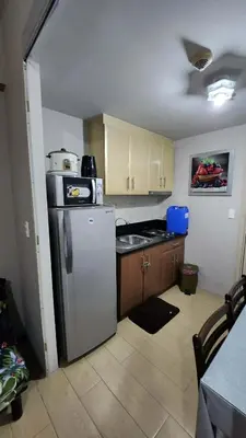 a kitchen with a refrigerator and a sink in it at 1OK South Wing in Manila
