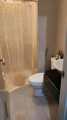a bathroom with a toilet and a shower and a sink at 1OK South Wing in Manila