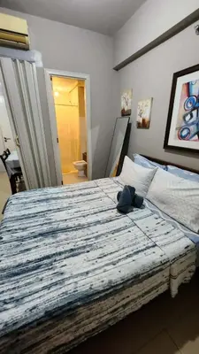 a bedroom with a bed with a blue stuffed animal on it at 1OK South Wing in Manila