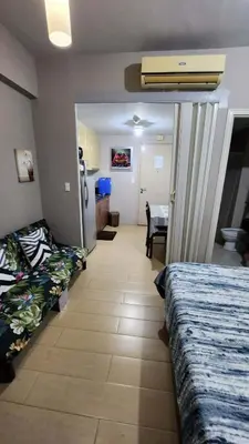 a room with two beds and a dining room with a table at 1OK South Wing in Manila