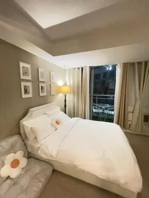 a bedroom with a white bed with a stuffed animal on it at Condo in Paranaque Near NAIA- Azure Paranaque in Manila