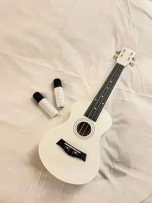 a guitar laying on a bed with two medicines at Condo in Paranaque Near NAIA- Azure Paranaque in Manila