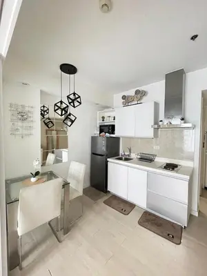 a kitchen with white cabinets and a stainless steel refrigerator at Condo in Paranaque Near NAIA- Azure Paranaque in Manila