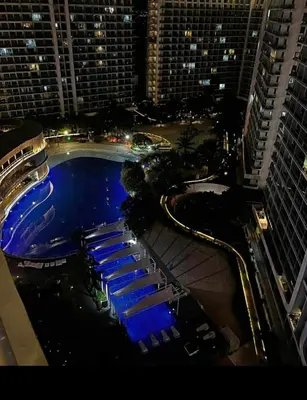 a view of a pool in a city at night at Condo in Paranaque Near NAIA- Azure Paranaque in Manila
