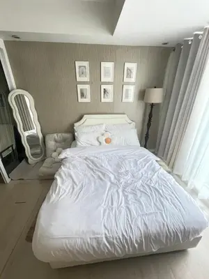a bedroom with a white bed with a stuffed animal on it at Condo in Paranaque Near NAIA- Azure Paranaque in Manila