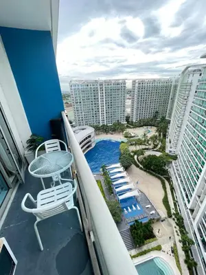 a balcony with a table and chairs and a pool at Condo in Paranaque Near NAIA- Azure Paranaque in Manila
