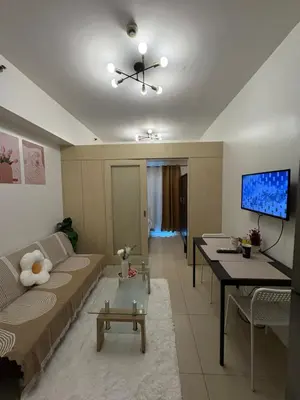 a living room with a couch and a tv at Condomatch Staycation in Manila