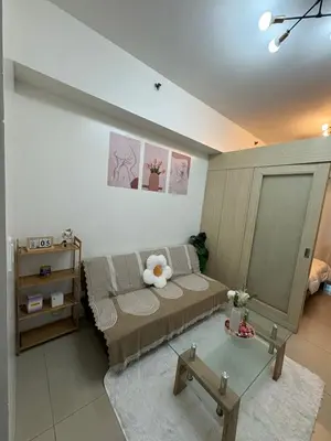 a living room with a bed and a glass table at Condomatch Staycation in Manila