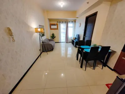 a living room with a dining table and a living room at Moonsky Suites in Manila