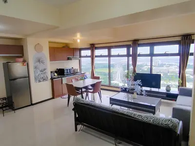 a living room with a couch and a table and a kitchen at Moonsky Suites in Manila