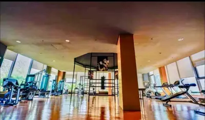 a gym with cardio equipment in a large room with windows at Moonsky Suites in Manila