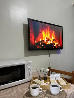 a living room with a fireplace with a flat screen tv at Althalia Grandsuites Staycation in Manila