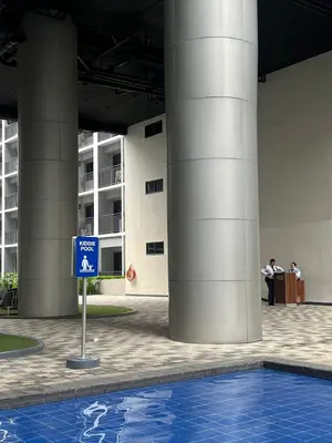 a blue sign in front of a building with a swimming pool at Althalia Grandsuites Staycation in Manila