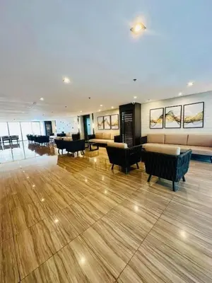 a large room with couches and tables in a building at Relaxing Escape 2 Beds Rattan Chair & 65 inch Smart TV in Manila