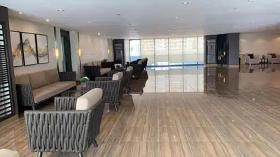 a lobby with chairs and couches in a building at Relaxing Escape 2 Beds Rattan Chair & 65 inch Smart TV in Manila