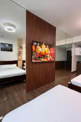 a room with two beds and a painting on the wall at Relaxing Escape 2 Beds Rattan Chair & 65 inch Smart TV in Manila